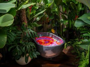 a large metal bucket filled with red and pink flowers at Villa Sun Soul - Brand New 2bed Villa w Rice Field View in Ubud