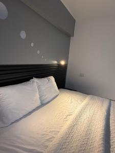 a bedroom with a bed with white sheets and pillows at Thompson House in Orotina