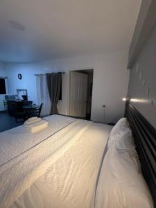 a bedroom with a large white bed in a room at Thompson House in Orotina