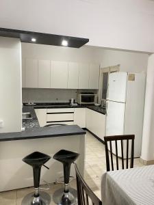 a kitchen with white cabinets and a white refrigerator at Marías in Resistencia