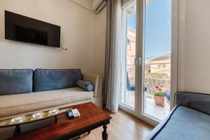 a living room with a couch and a sliding glass door at Venetian Balcony , Old Town Corfu in Corfu
