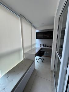 a small room with a desk and a table at Apartamento Moderno uma quadra do mar in Vila Velha