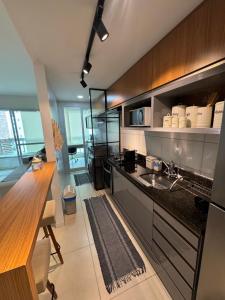 a kitchen with a sink and a counter top at Apartamento Moderno uma quadra do mar in Vila Velha +6 photos