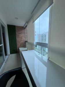 an empty room with a large window in a building at Apartamento Moderno uma quadra do mar in Vila Velha