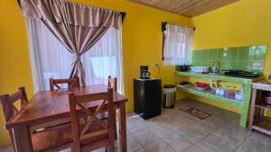 a kitchen with a wooden table and a kitchen with yellow walls at Rústicas Dani & Fam in Fortuna