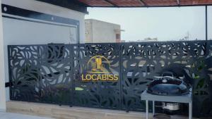 a wall with a gate with a logo on it at Locabiss 5, ALMADIES 2 in Rufisque