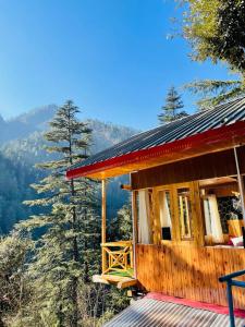 a wooden cabin with a view of the mountains at Hideaway Tree House in Jibhi