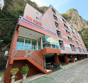 a building with a staircase in front of a mountain at Aonang Mountain View A1 in Ao Nang Beach