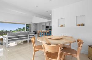 a dining room with a wooden table and chairs at Acqua Vista in Terrigal