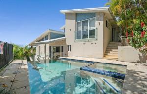a house with a swimming pool in front of a house at Acqua Vista in Terrigal