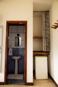 a bathroom with a sink and a toilet and a mirror at Bella Pousada in Abraão +88 photos
