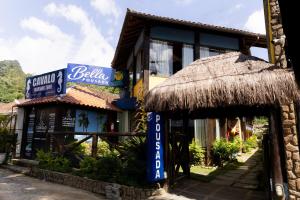 a building with a straw roof and a restaurant at Bella Pousada in Abraão
