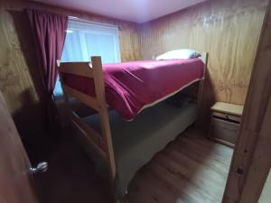 a bunk bed in a small room with a window at Casa Cardenal in Castro