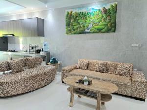 a living room with two couches and a table at Paddy Villa Sanur in Sanur