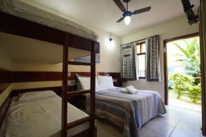 a bedroom with two bunk beds and a window at Bella Pousada in Abraão