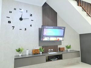 a living room with a large clock on the wall at Paddy Villa Sanur in Sanur
