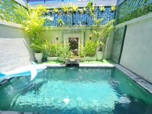 a pool of water in a backyard with plants at Paddy Villa Sanur in Sanur