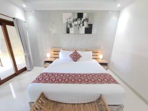 a bedroom with a large white bed in a room at Paddy Villa Sanur in Sanur +30 photos