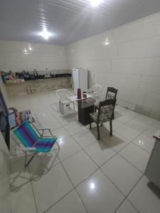 an empty room with chairs and a table and a table and chairs at Casa moto gp in Goiânia