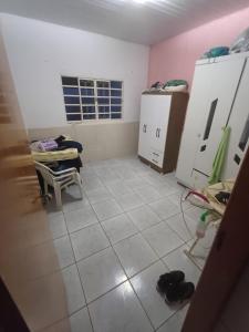a room with a white tiled floor and white cabinets at Casa moto gp in Goiânia