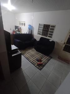 a living room with black couches and a rug at Casa moto gp in Goiânia