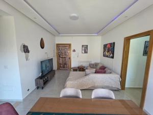 a living room with a couch and a tv at Primavera Marmara Hamam sousse in Hammam Sousse