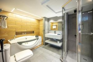 a bathroom with a tub and a toilet and a sink at Quiet Dreams - Serviced Apartments King abdul Aziz Street Branch in Jeddah +68 photos