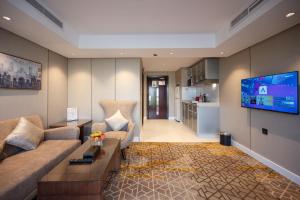 a living room with a couch and a flat screen tv at Quiet Dreams - Serviced Apartments King abdul Aziz Street Branch in Jeddah