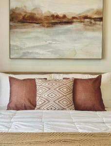 a painting hanging above a bed with pillows at Ivory Davao Condotel near DMSF in Davao City +10 photos