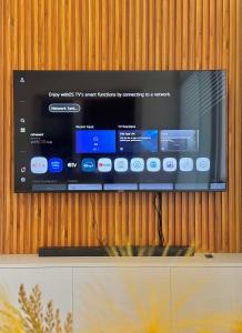 a flat screen tv on a wooden wall at Ivory Davao Condotel near DMSF in Davao City