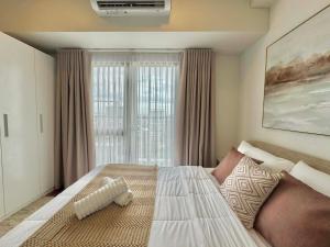 a bedroom with a large bed in front of a window at Ivory Davao Condotel near DMSF in Davao City