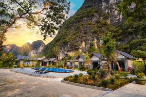 a resort with a mountain in the background at Trang An River View Ecolodge in Ninh Binh