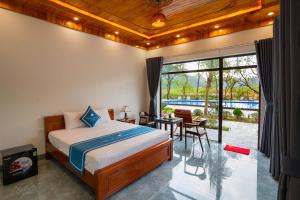 a bedroom with a large bed and a patio at Trang An River View Ecolodge in Ninh Binh