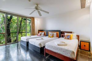 a bedroom with two beds and a ceiling fan at V302 Exclusive Seaview 7BR Infinity Pool Villa in Por Bay +121 photos