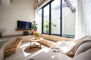 a living room with a couch and a large window at Casa pumara loft in Kerobokan