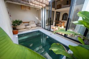 a swimming pool in a house with plants at Casa pumara loft in Kerobokan