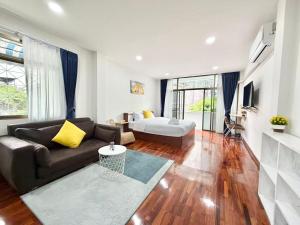a living room with a couch and a bed at S Hostel sukhumvit48 Near Phrakanong BTS 2001 in Bangkok