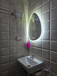 a bathroom with a sink and a mirror at Sherans Cottage in Umargām