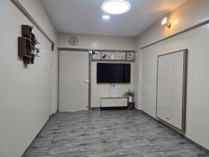 a hallway with a door and a television and a room at Sherans Cottage in Umargām +4 photos