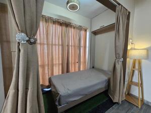 a small bedroom with a bed and a window at Sherans Cottage in Umargām