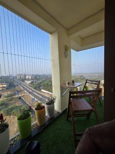 a balcony with a bench and plants and a view at Sherans Cottage in Umargām