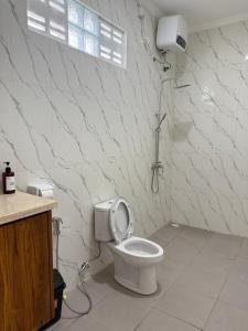 a bathroom with a white toilet with a shower at Puri Lepang Riverside in Ketewel +7 photos
