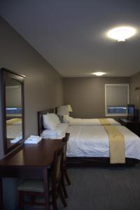 a hotel room with a bed and a table and a mirror at Rainbow INN in Terrace