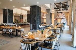 a dining room with tables and chairs in a restaurant at Tunjong Stay in Kota Bharu