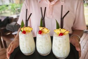 a man holding three cocktails with fruit in them at The Woods Beachfront Tent Yao Noi in Ko Yao Noi +39 photos