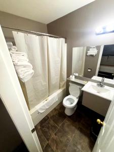 a bathroom with a shower and a toilet and a sink at Rainbow INN in Terrace
