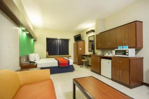 a hotel room with a bed and a kitchen at Microtel by Wyndham Eagle Ridge in General Trias
