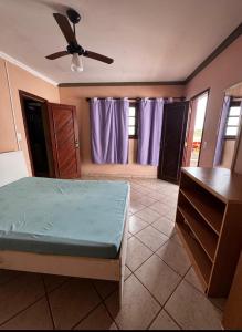 a bedroom with a bed and a ceiling fan at Casa Marron in Anchieta