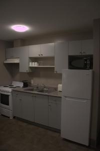 a kitchen with white cabinets and a white refrigerator at Rainbow INN in Terrace +12 photos
