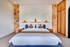 a bedroom with a large white bed and two mirrors at Tresna Villa Tumbak Bayuh Utara in Dalung +49 photos